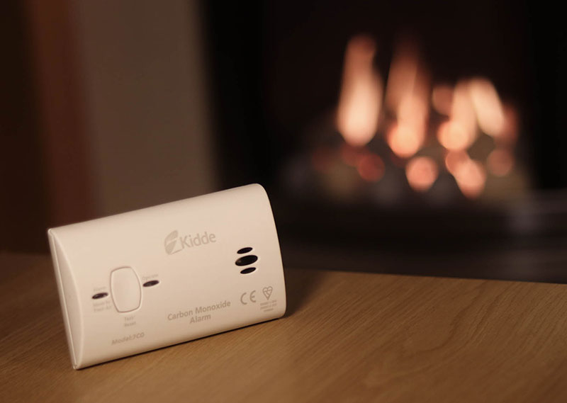 A carbon monoixde alarm in a room with a gas fire