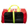 Emergency evacuation sledge packed on its side with red and black material and yellow handles