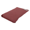 angled view of a small flat astro pillow in a muted red colour with a fabric tag attached