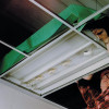 Aflumican Astro Lumi Canopy Installation Below showing wiring and a person fitting the green canopy cover on ceiling panels