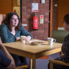 p50 2ltr water mist fire extinguisher hanging on a brick wall behind two people talking over drinks at a table