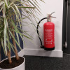 p5 6ltr water mist extinguisher mounted on a wall next to a plant in a white pot