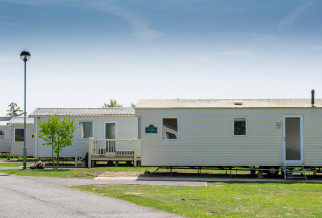 A row of static caravans against a clear blue sky