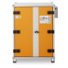 A tall industrial cabinet with an orange front panel, grey centre strip, black hinges, central handle, and hazard‑symbol label on the upper right.