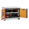 Open metal cabinet containing multiple chargers and power‑tool batteries arranged on two shelves, with safety information on the door.