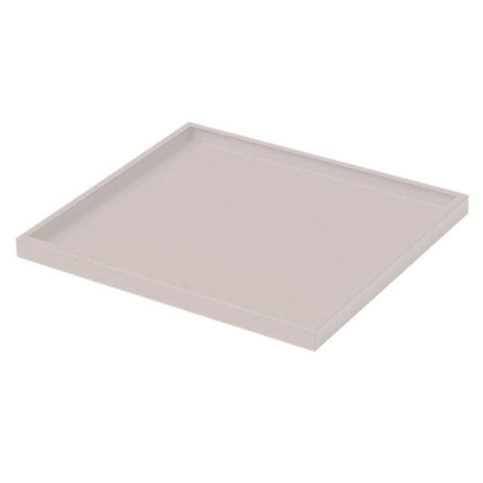 angled view of single shelf from first aid cabinet in plain light colour with raised edges