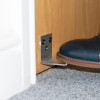 decamed stainless steel foot operated door opener installed on wooden door with foot pressing on lever