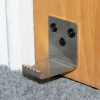 stainless steel foot operated door opener decamed attached to door near floor with carpet beneath