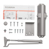 dorma door closer with metal arm, main body, screws, bracket, and installation instructions laid out on white background