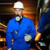 Man wearing a drager 3200 fire escape mouth piece and protective clothing in a work environment