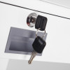 A pair of drawer keys inserted in a silver lock on a white drawer front