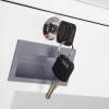 Two drawer keys inserted in a metal lock on a white drawer with a rectangular handle