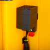 Closeup of the heater inside a polycarbonate outdoor defibrillator cabinet heating light yellow showing black casing and power cables