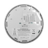 Rear view of a smoke alarm with labels, manufacturer details, warning text, and central wiring connectors visible on the mounting plate.