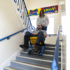 Man being pushed down stairs in evac chair 300h evacuation chair by woman in a stairwell