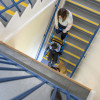 Top view of the evac chair 300h evacuation chair carrying a person downstairs on a stairwell with blue handrails