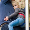 Child wearing paraid child carrier harness held by adult during an emergency situation