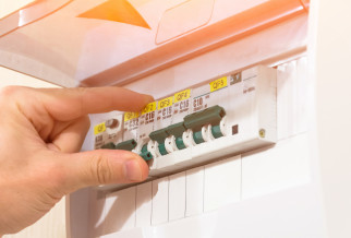Someone switching of a fuse on a fuse board