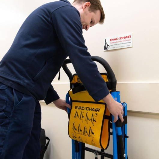 Engineer installing an evacuation chair on a hook