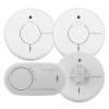 Four FireAngel alarms including two circular smoke alarms and a heat alarm with test/silence buttons and an oval carbon monoxide alarm with multilingual labelling.