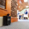 dorgard fire door retainer attached to door in foreground with people sat at table in background