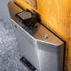 dorgard stainless steel cover fixed on the top of a wooden door showing metal surface and screws