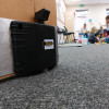 dorgard smartsound door retainer fitted at the base of an open door with a family playing in the background