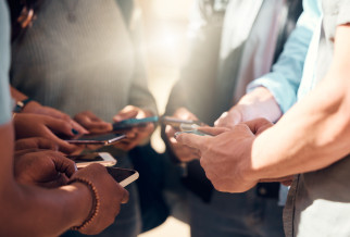 A group of people with their phones in a circle
