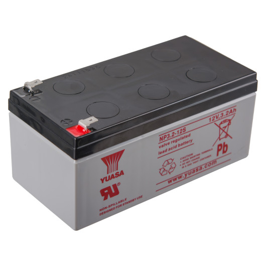 Angled view of a 12v battery fire alarm panel psu with a grey body and black top showing labelled terminals