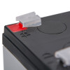 Closeup of 12v battery fire alarm panel psu showing black casing and red positive terminal cover