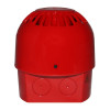 A red fire alarm sounder viewed from the back, featuring a dome-shaped top with vent slots and a square base with circular cable entry knockouts and a small warning symbol.