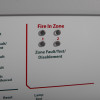 Closeup of indicator lights on kentec sigma cpr 2 zone repeater panel showing fire in zone and fault test disablement labels