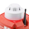 A close-up of a fire safety device showing the white smoke detector on a red base, with a black antenna positioned next to it. The red housing features printed warning and certification icons.