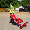 Man in a high-visibility vest pulling the Fmctf7 Fmc Site Trolley With Extinguishers In Situ with two red extinguishers attached