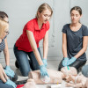 Group of people practising CPR and AED use on mannequins during Frtotaed First Response Training Aed And Cpr Course Group Session