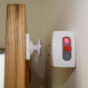 Geofire Agrippa acoustic fire door holder attached to a wall holding a wooden door in place with a red light showing