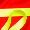 Close-up of bright yellow straps on the hospital aids ski pad and storage bag against a red background