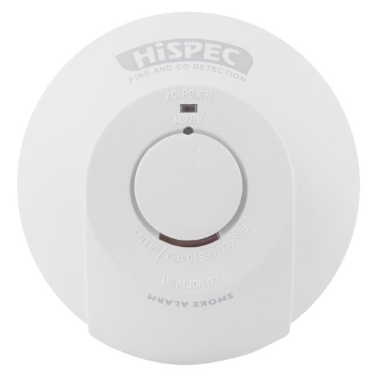 White circular smoke alarm labeled “FIRE AND CO DETECTION” with a central button for testing and silencing, and indicators for “AC POWER” and “ALARM.”