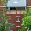 Hs2Stfel Hs3Stfel Ultrafire Fire Escape Ladder Office 9 hanging from an open window on a brick wall with plants in foreground