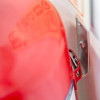 Close up of a fire extinguisher j bracket mounted insitu with a red handle visible