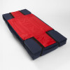 Padded medical evacuation stretcher with navy blue cushioning, red central sling, and four black securing straps, laid flat