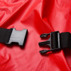 Close-up of a black plastic buckle on an evacuation sheet for active mattress air mattress placed on a red surface