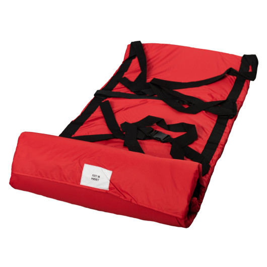 Unrolled evacuation sledge with wall mounted storage bag showing red fabric and black straps laid flat