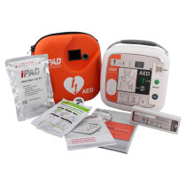 A white defibrillator next to a bright orange carry case