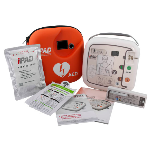 A white defibrillator next to a bright orange carry case