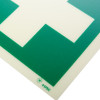 Close up of the corner of a first aid sign rigid plastic showing green and white sections