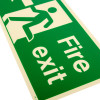 Close up of fire exit sign rigid plastic left side j showing green and white design with running figure and text Fire exit