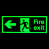 Fire exit sign rigid plastic left size k glowing green on black background in dark
