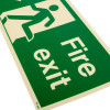 Close up of a fire exit sign rigid plastic down left size j showing green panel with white running figure and text Fire exit
