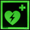 aed location sign showing a green heart with a lightning bolt and medical cross on a dark background